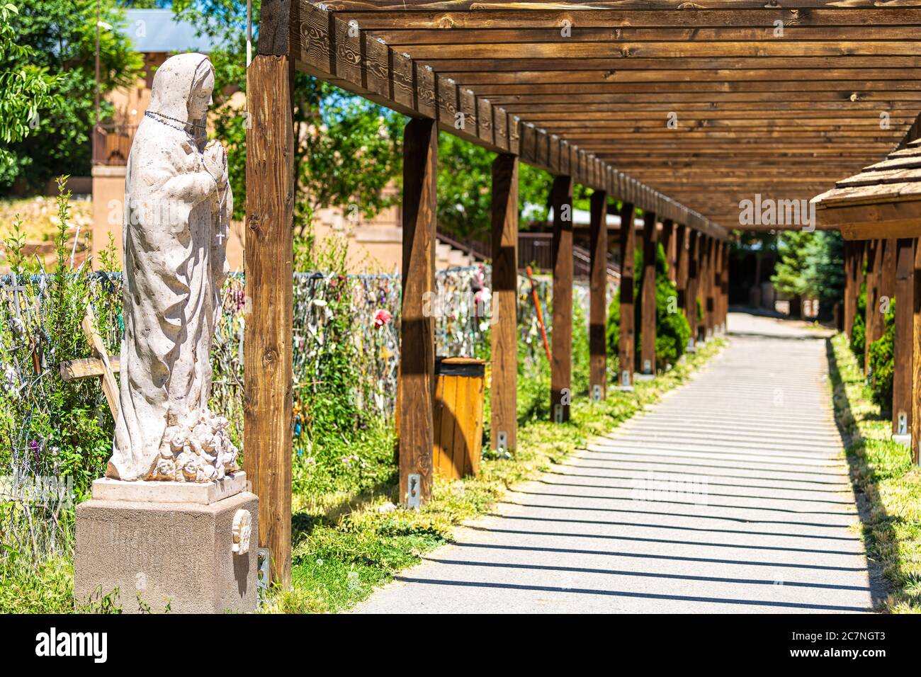 Chimayo, USA - 19 juin 2019 : église sanctuaire El Santuario de Chimayo aux Etats-Unis avec passage d'entrée et statue vierge de Marie Banque D'Images