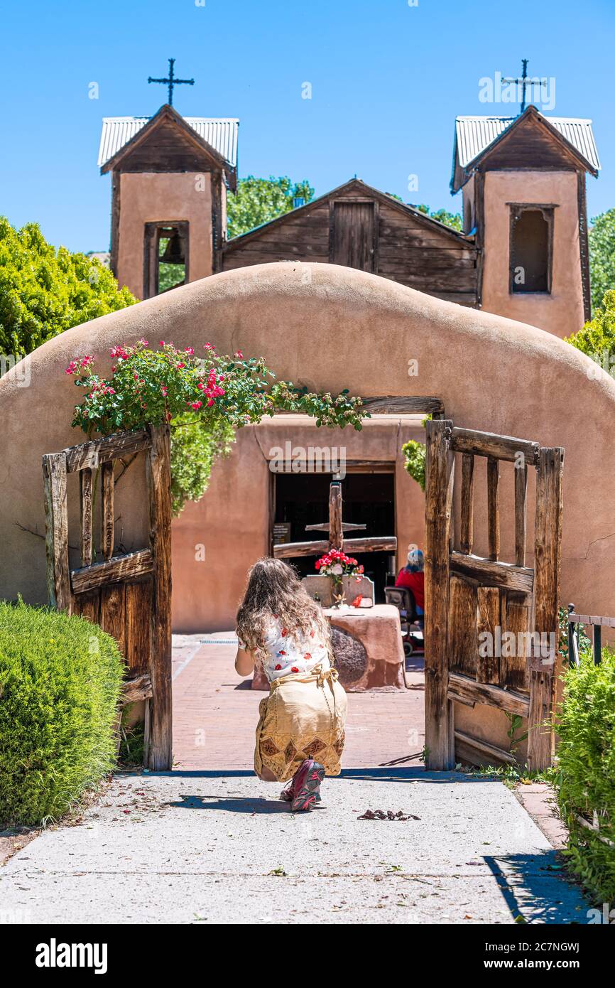 Chimayo, USA - 19 juin 2019: El Santuario de Chimayo sanctuaire église aux Etats-Unis avec porte d'entrée et femme priant pour le miracle Banque D'Images