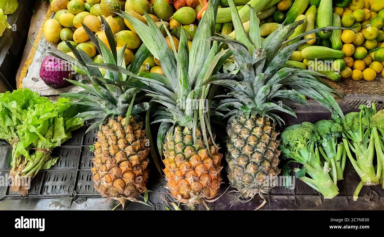 Magasin de fruits avec ananas et mangues à la vente sur un marché de la ville Banque D'Images