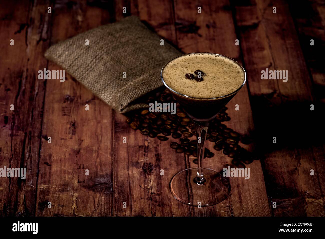 Dose d'espresso martini à grand angle avec grains de café sur une surface en bois Banque D'Images