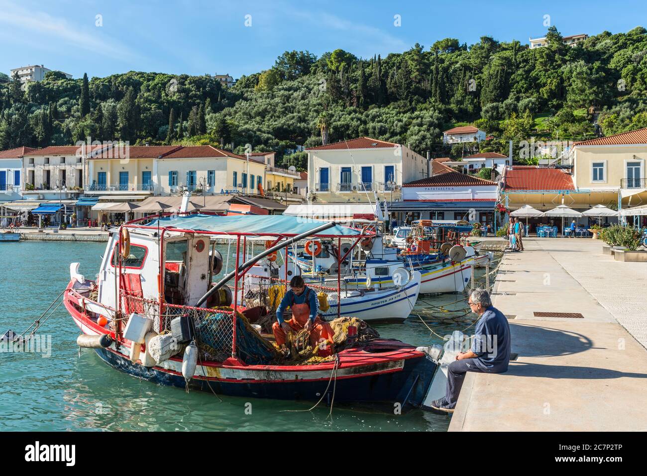 Katakolo, Grèce - 11 novembre 2019 : un pêcheur grec démonte le filet de pêche dans un bateau de pêche en bois dans le port de Katakolo (Olimpia), Grèce. Banque D'Images