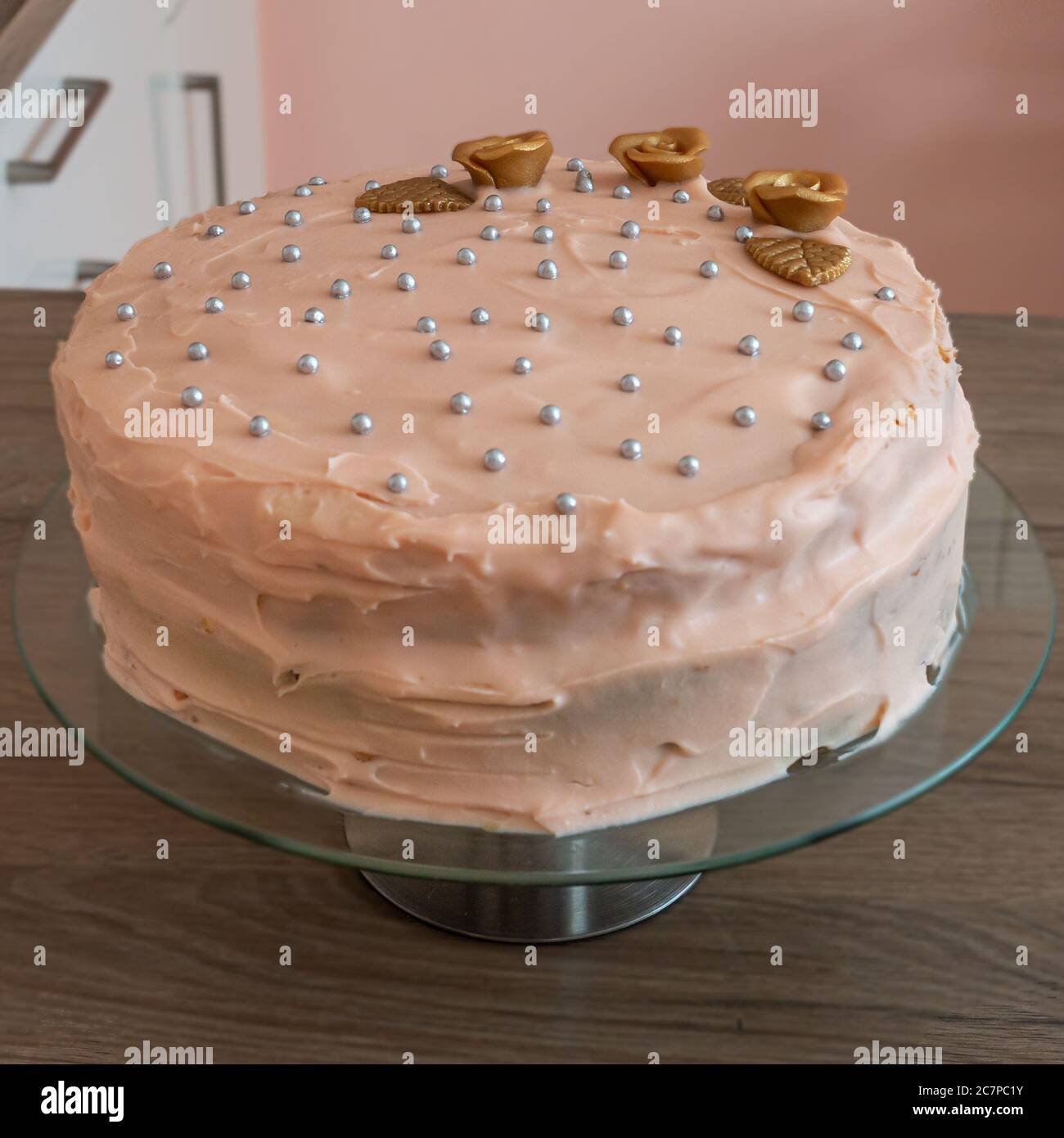 Delicieux Gateau A La Vanille Recouvert D Une Glacage Cremeux Et Decore De Perles D Argent Et De Fleurs Dorees Sur Un Support En Verre Pour Gateaux Photo Stock Alamy