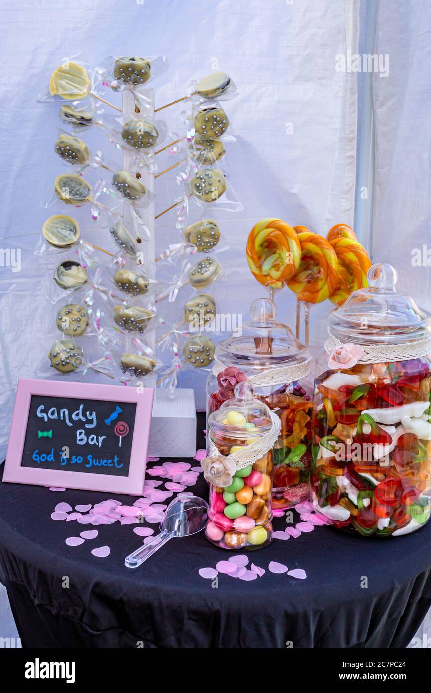 Table avec présentation de petites barres de bonbons avec des pop-suits au chocolat, des pop-sucreries, des pots en verre avec différentes bonbons aux saveurs et aux couleurs. Dieu Banque D'Images