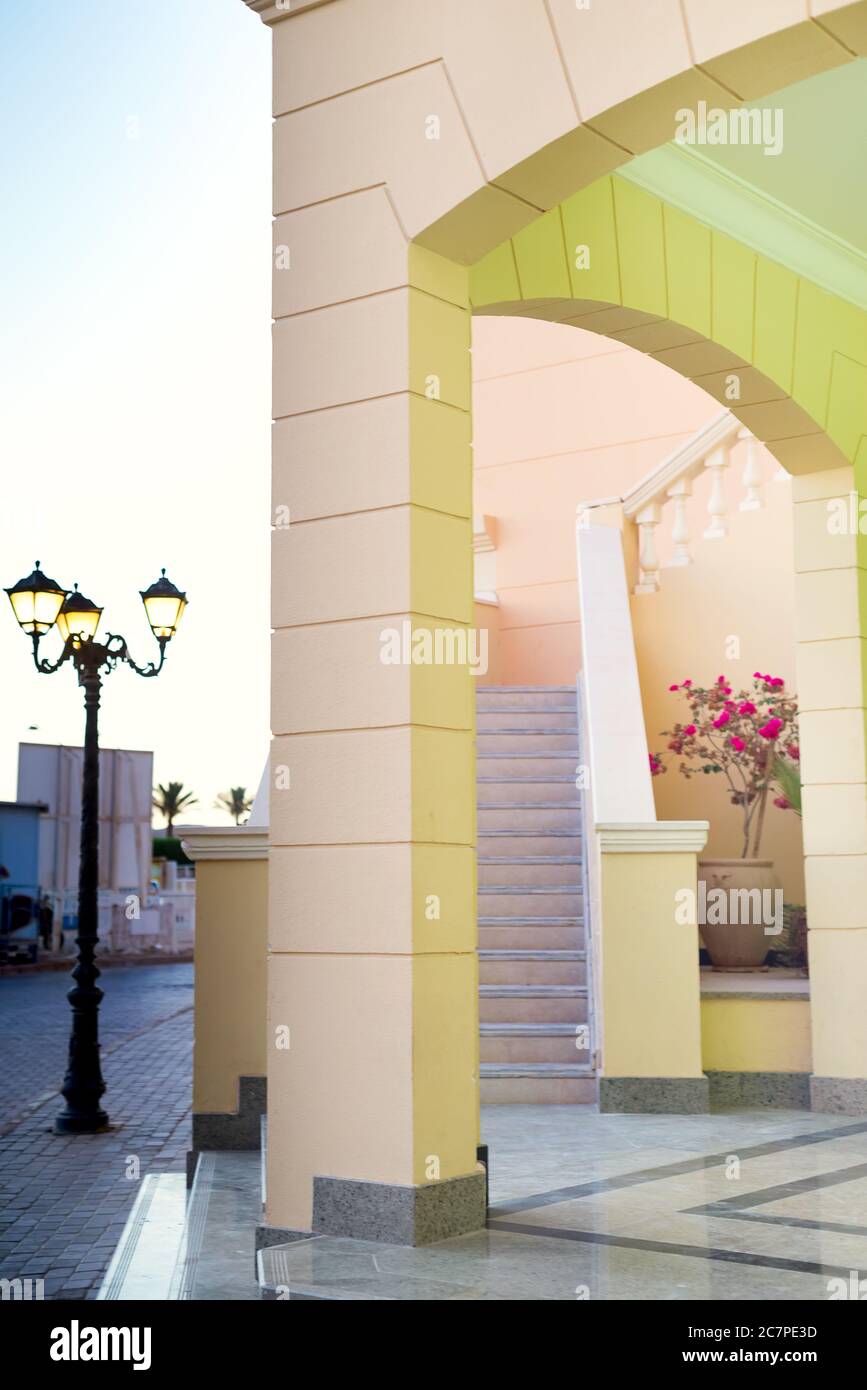 Bâtiment moderne de l'hôtel avec arches architecturales, escalier et lampes de rue près de la maison, un jour ensoleillé d'été, un espace de copie. Concept de voyage d'été. Banque D'Images