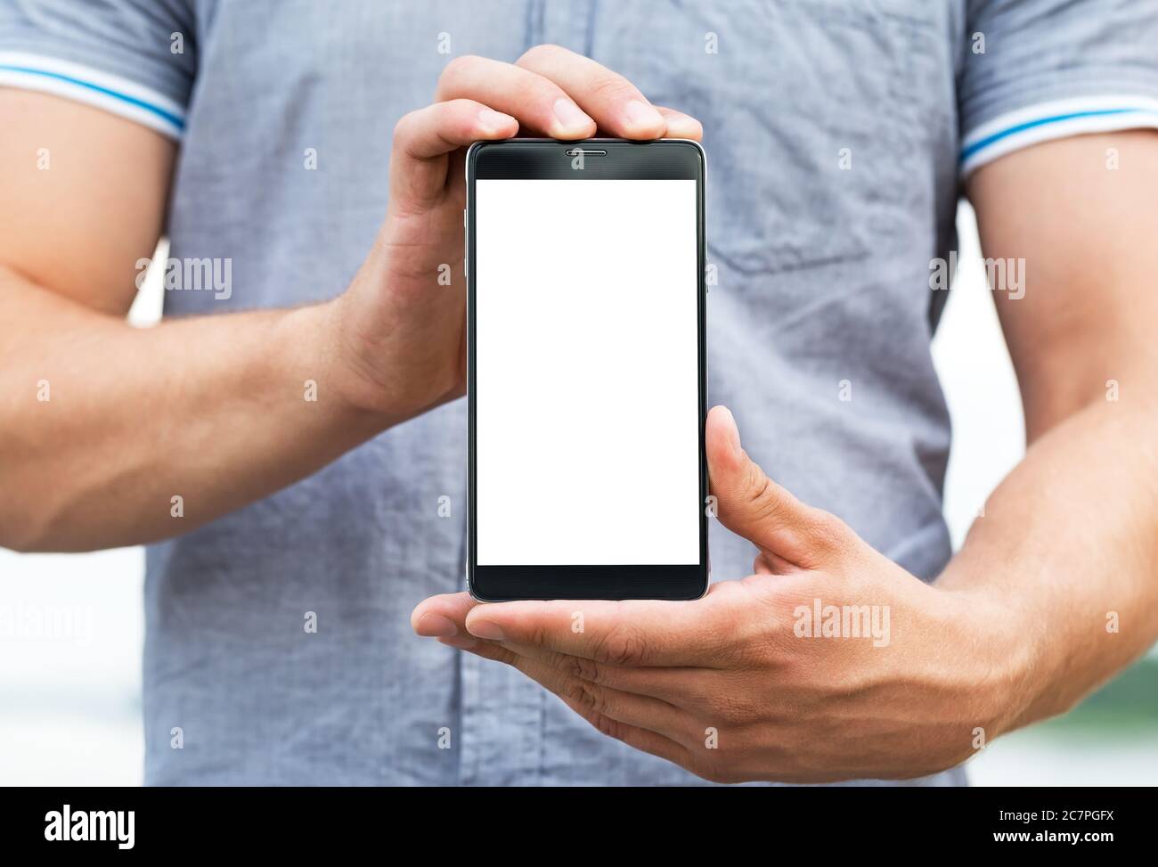 Jeune homme montrant une application de téléphone mobile, gros plan Banque D'Images
