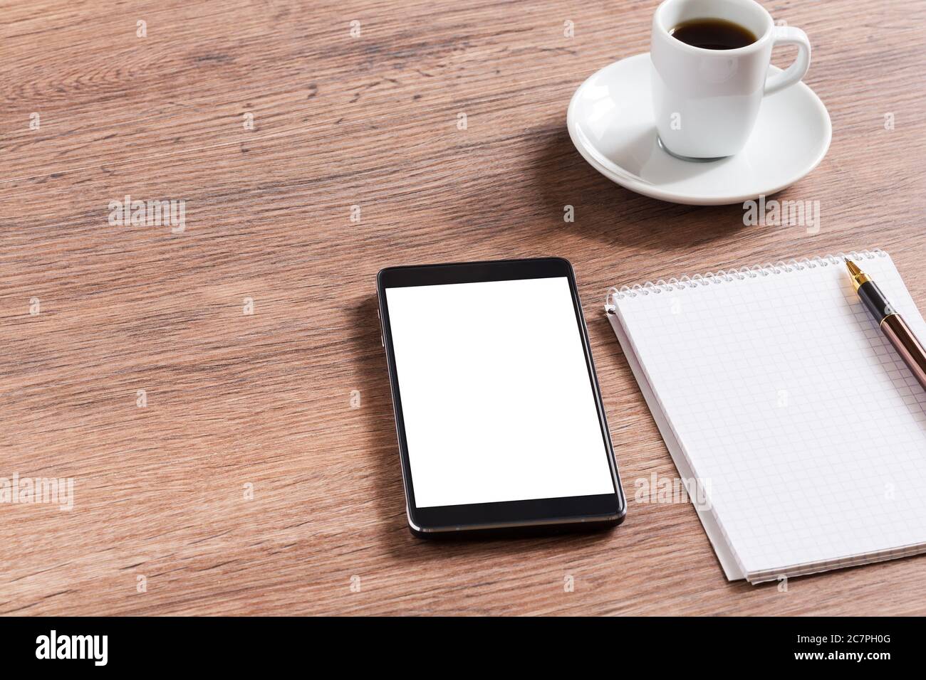 Ordinateur portable avec stylo, smartphone et café sur table en bois Banque D'Images