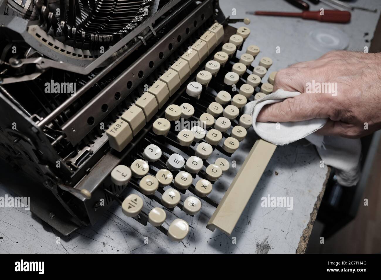 Vieil homme essuyant la machine à écrire vintage Banque D'Images