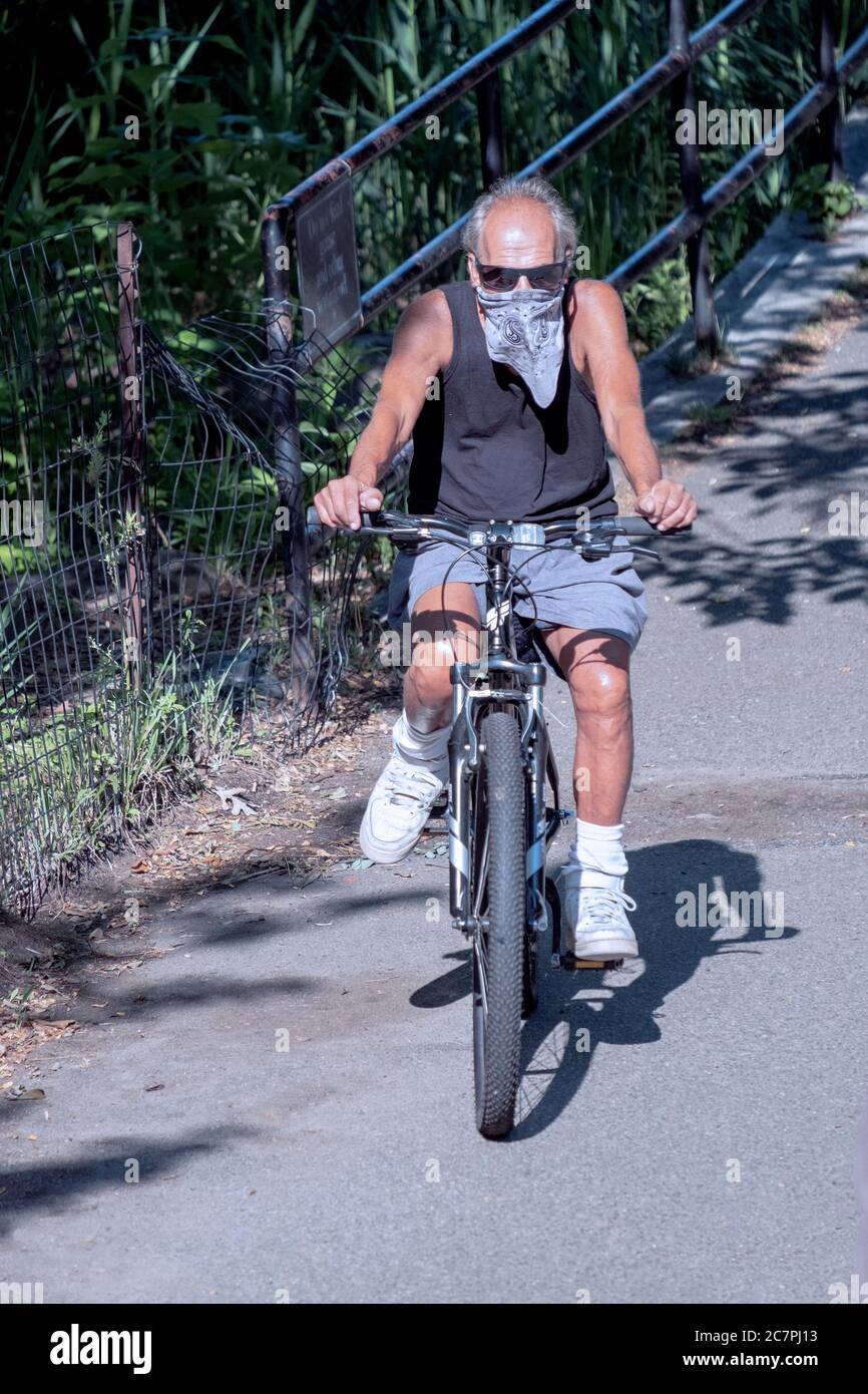 Un homme plus âgé portant un bandana fait le tour de son vélo sur un chemin  dans un parc à Flushing, Queens, New York City Photo Stock - Alamy