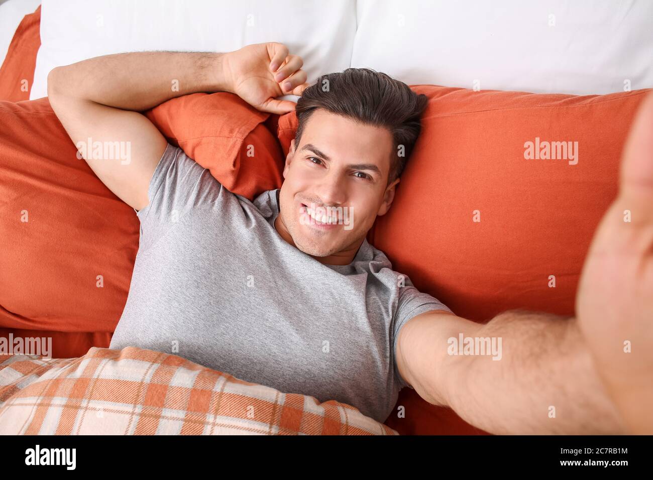 Matin du jeune homme prenant le selfie au lit Photo Stock - Alamy