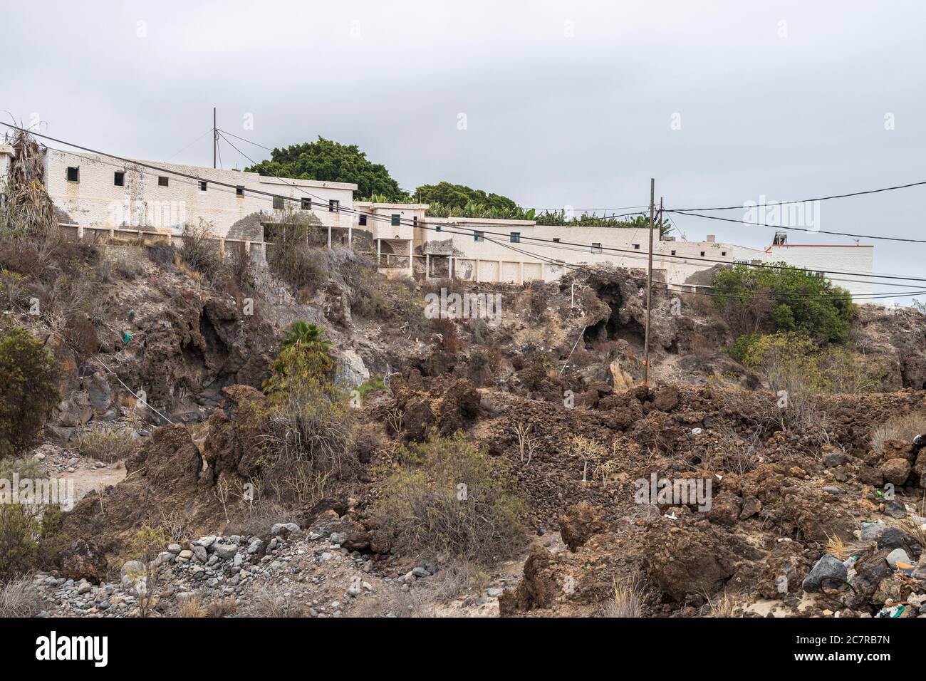 Rangée mitoyenne de vieilles maisons de travailleurs de finca abandonnés au-dessus d'un barranco à Playa San Juan, Tenerife, îles Canaries, Espagne Banque D'Images