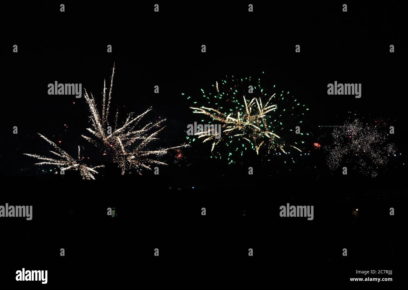 Des fusées d'araignées et des feux d'artifice de fusée chrysanthème explosent depuis un toit de New York le 4 juillet 2020 contre un ciel noir de nuit avec Banque D'Images