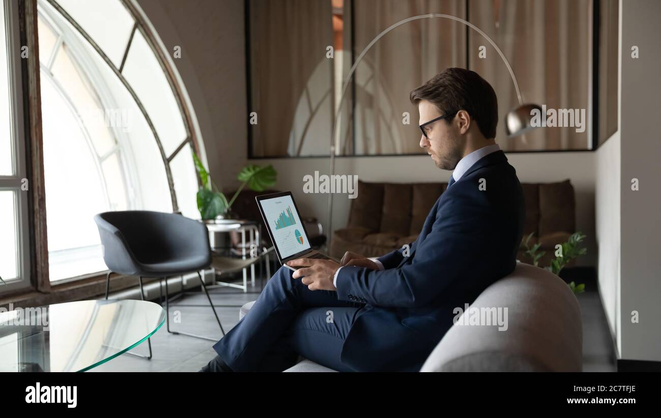 Un homme d'affaires sérieux travaille sur un ordinateur portable pour analyser les finances Banque D'Images