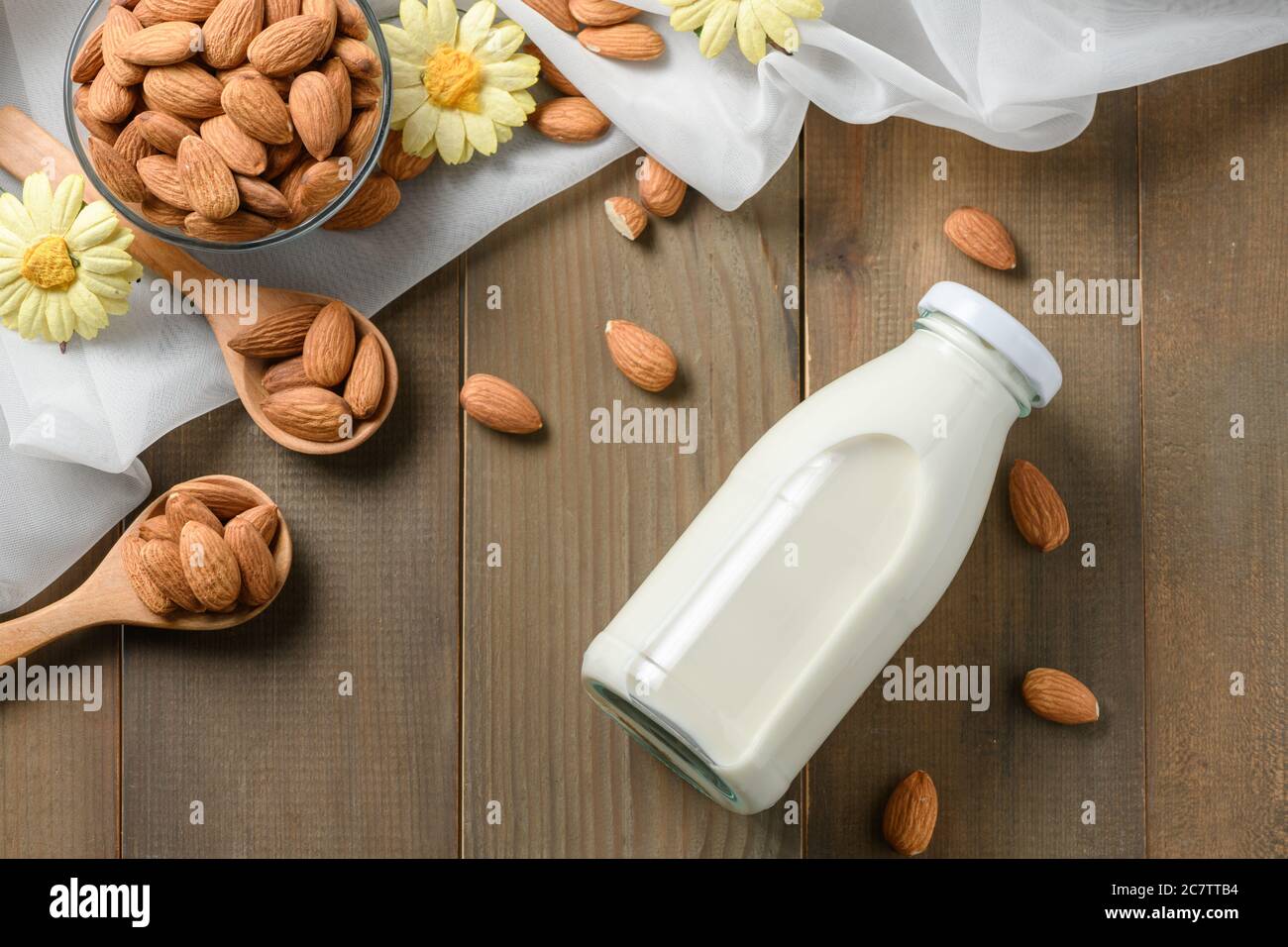 Bouteille de lait frais et amandes noix sur fond de table de bois, les amandes sont des noix très populaires et des protéines élevées . nourriture saine. Banque D'Images