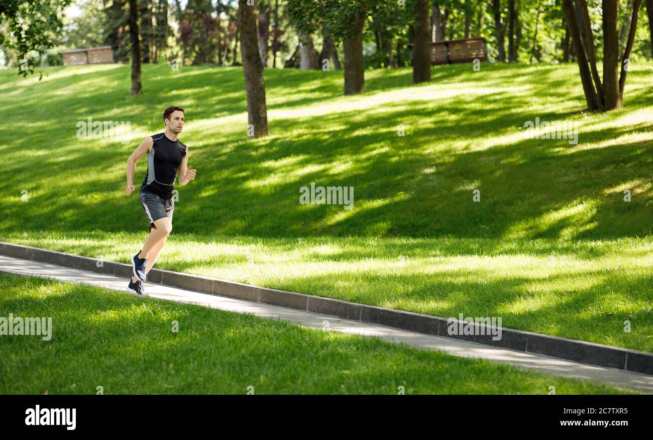Gars en sport jogging sur piste, sur pelouse dans le parc Banque D'Images