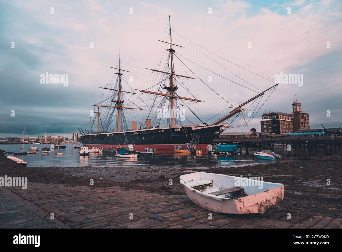 HMS Warrior amarré à Portsmouth avec un vieux bateau de pêche au premier plan sur le quai Banque D'Images