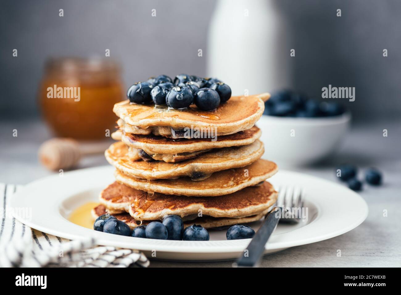 Faire des crêpes d'avoine avec des bleuets et du miel sur une assiette blanche. Pile de crêpes végétariennes saines, pancakes paléocarb bas Banque D'Images