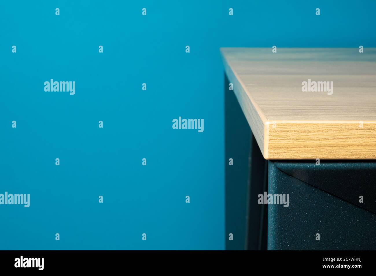 Gros plan d'un coin de table mobilier en bois massif avec fond bleu Banque D'Images