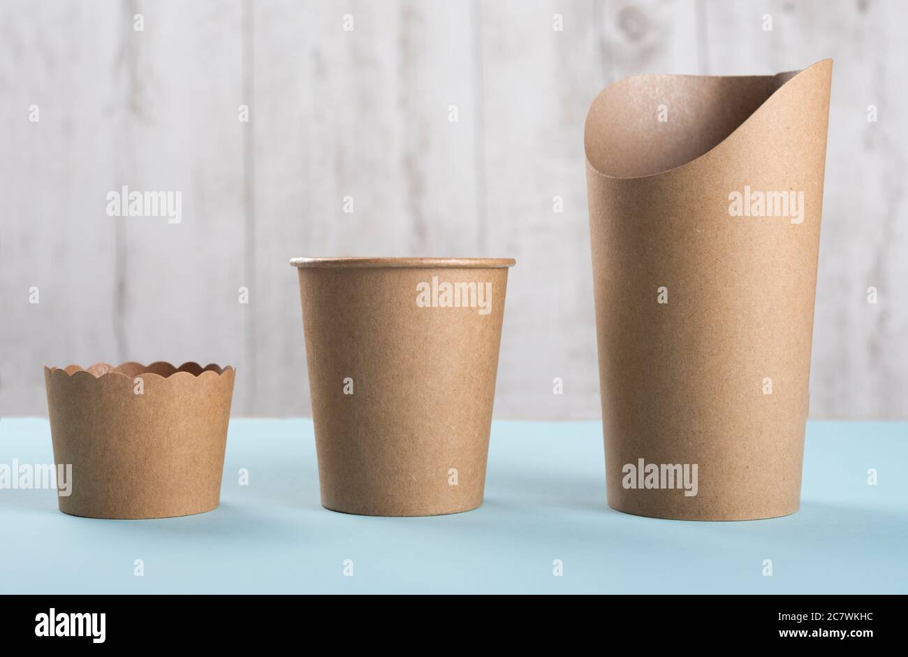 Tasses jetables et cupule de cuisson sur fond clair. Concept de recyclage. Banque D'Images