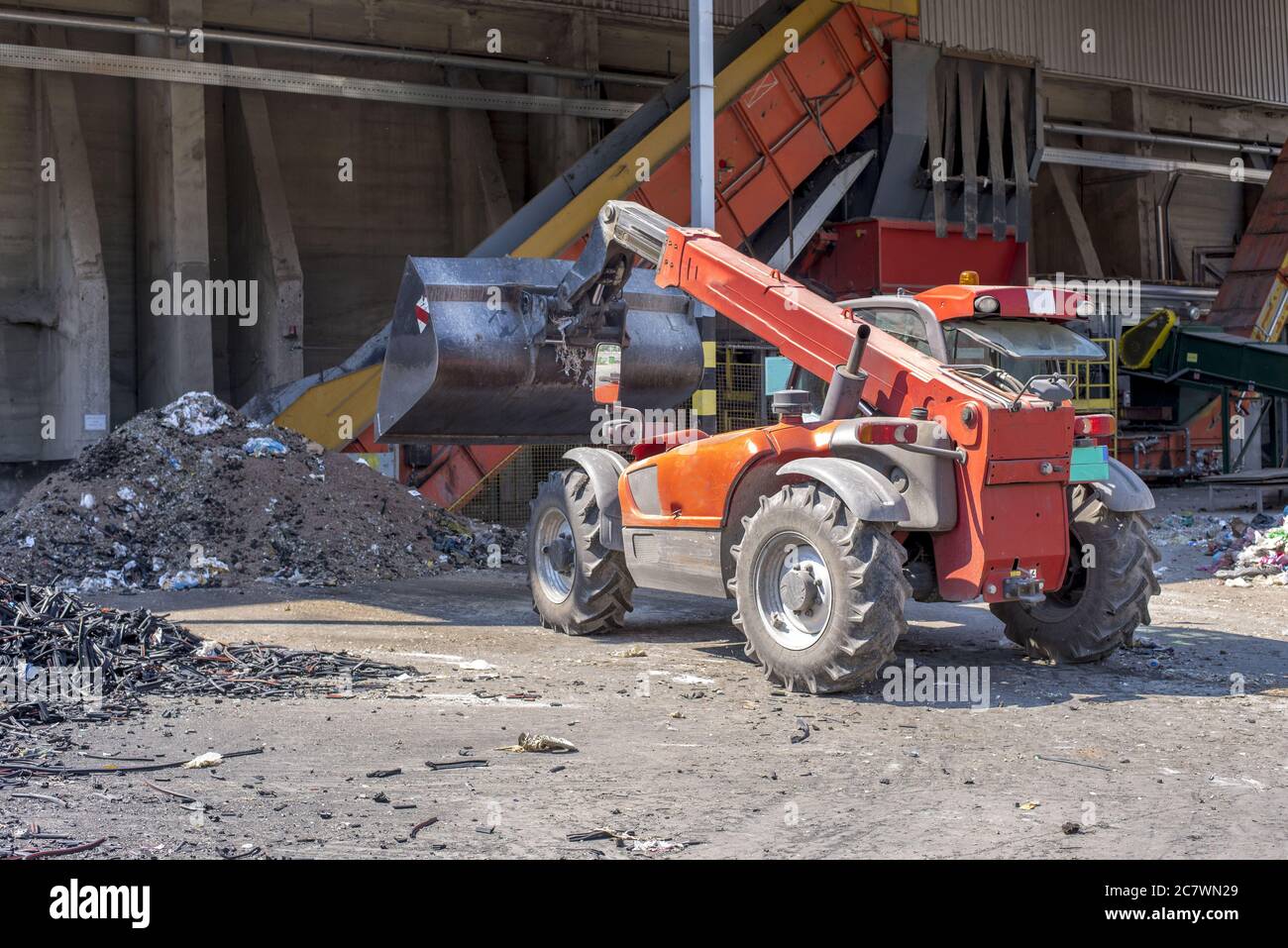 Chargeur transportant du sol et des déchets lors d'un traitement des déchets usine Banque D'Images