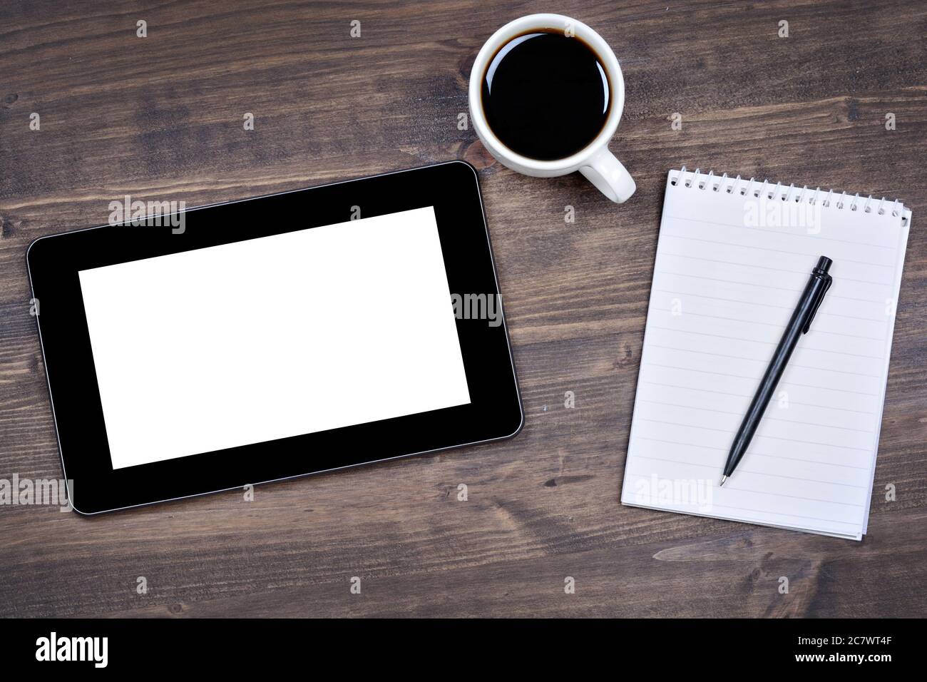 Appareil à écran tactile, bloc-notes, stylo et tasse de café sur table en bois Banque D'Images