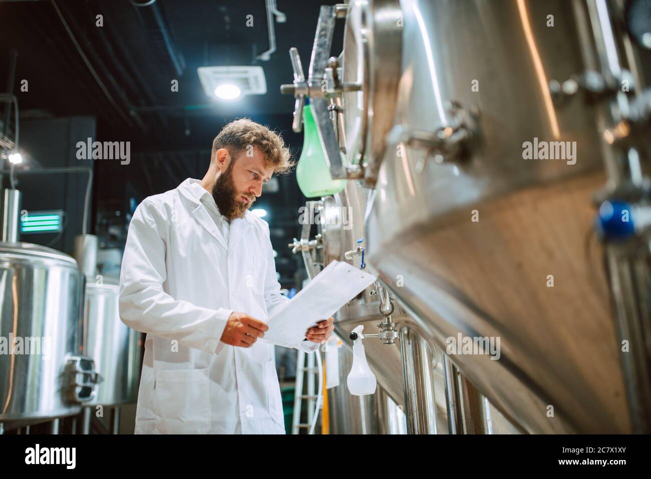 Expert en technologue de race blanche en fonctionnement de machine de production dans une usine alimentaire et en contrôle qualité et en tenue de liste de contrôle Banque D'Images