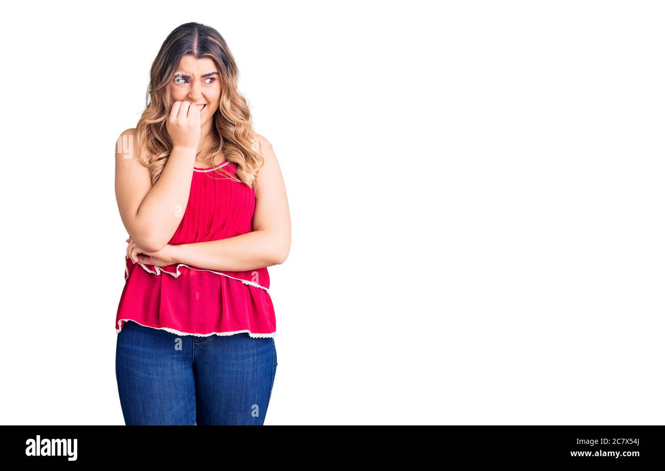 Jeune femme caucasienne portant des vêtements décontractés, aspect stressé et nerveux avec les mains sur la bouche piquant les ongles. Problème d'anxiété. Banque D'Images
