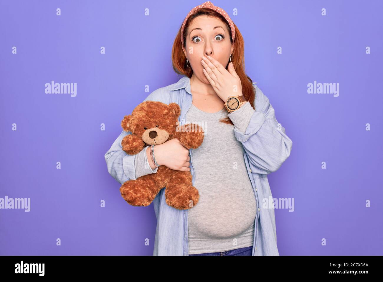 Jeune femme enceinte à tête rouge s'attendant à un bébé tenant un ours en  peluche sur fond violet couvrir la bouche avec la main choquée de honte  pour l'erreur, l'expression Photo Stock -