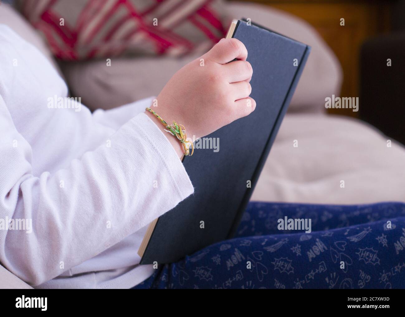 Femme assise dans une chambre confortable et lisant un livre Banque D'Images