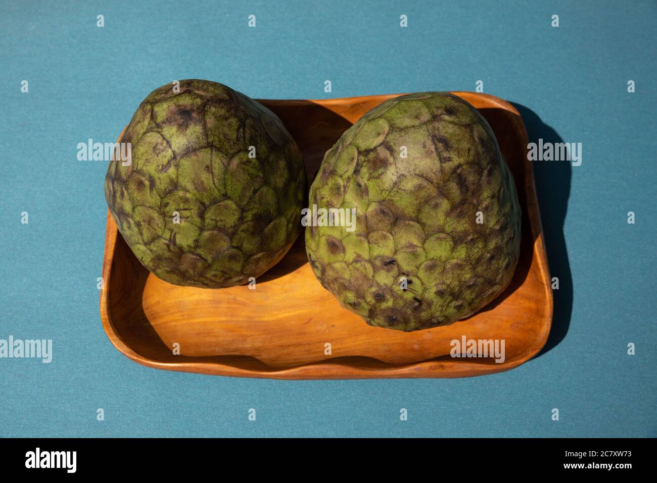 Vue de dessus des pommes de crème mûres sur fond bleu. Pommes de crème fraîche et biologique sur un bol en bois. Banque D'Images