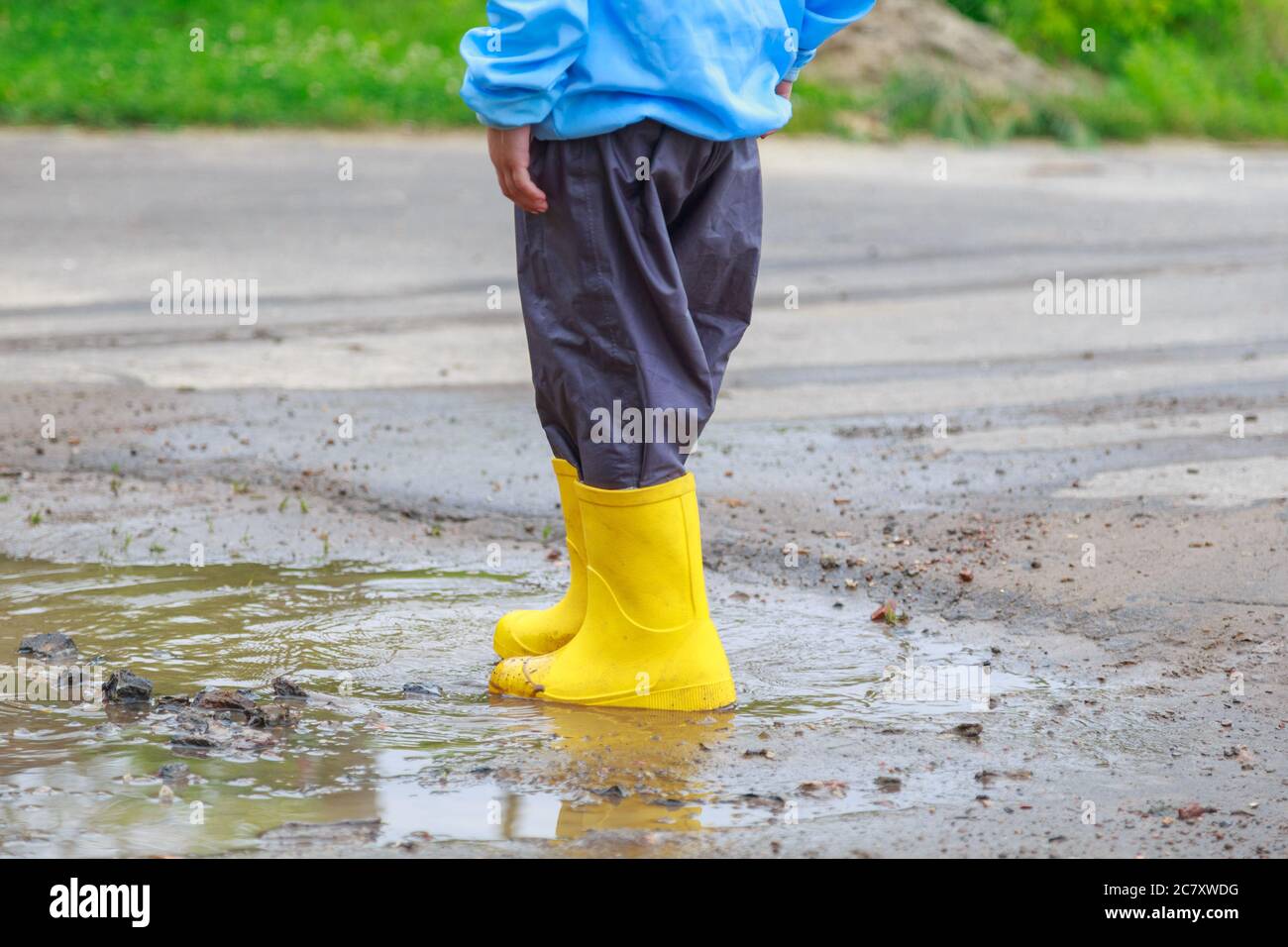 Pieds d'enfant dans des bottes en caoutchouc jaune sautant par-dessus la  flaque sous la pluie Photo Stock - Alamy