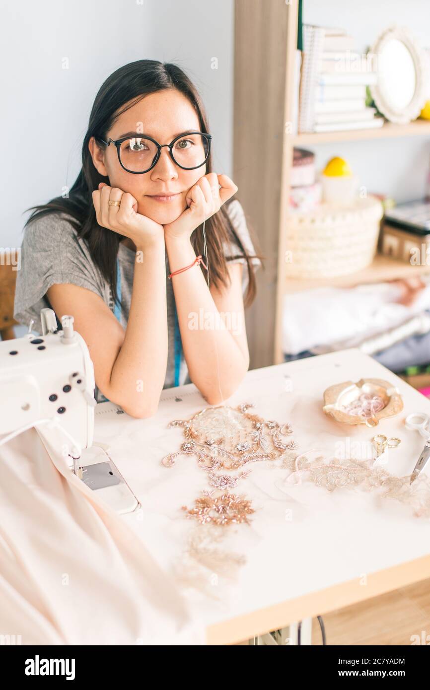 Une jolie couturière jeune a fait un nouveau vêtement en cadeau dans un atelier de couture. Banque D'Images