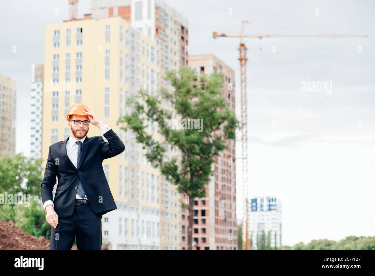 Beau, jeune ingénieur, contremaître, architecte-constructeur se penche sur la construction de la structure, à la gare, le port d'un casque de protection blanc, sm Banque D'Images