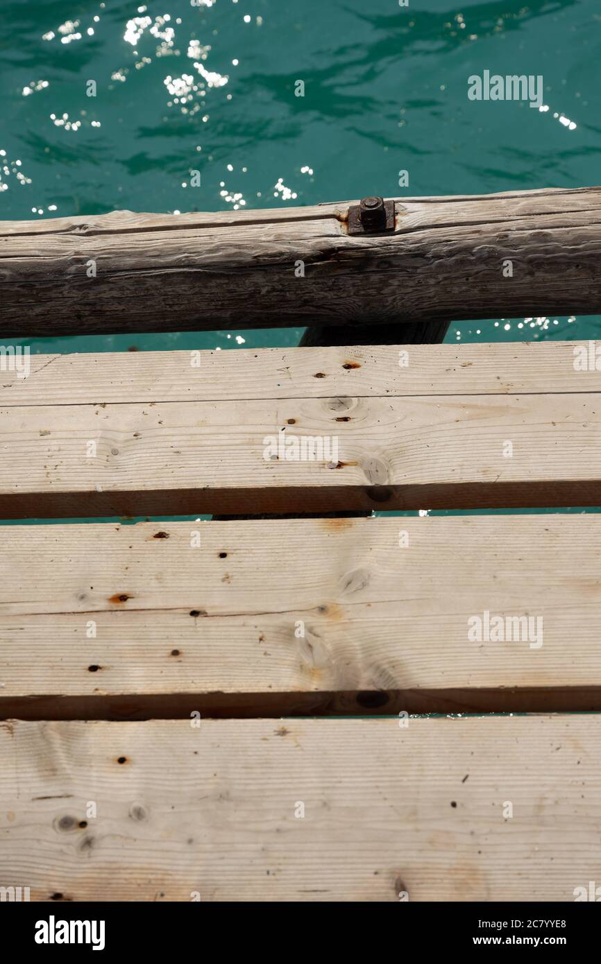 Une plate-forme de planches en bois se trouve au-dessus de la mer Méditerranée bleu turquoise en Grèce et est un endroit idéal pour un pique-nique ou un bain de soleil. Banque D'Images