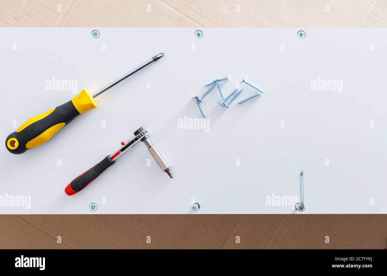Mobilier blanc dans les processus de collecte. Tournevis pour outils à main sur étagère de placard. Déménagement, rénovation, réparation de meubles. Vue de dessus Banque D'Images