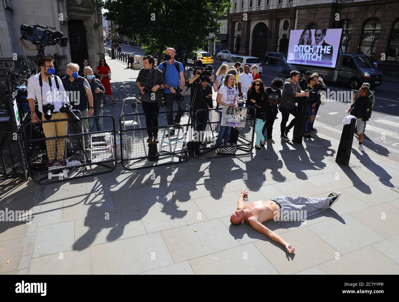 Un homme sans domicile se trouve devant les médias avant que l'acteur Johnny Depp arrive à la High court de Londres pour une audience dans son affaire de diffamation contre les éditeurs de The Sun et son rédacteur en chef, Dan Wootton. Banque D'Images