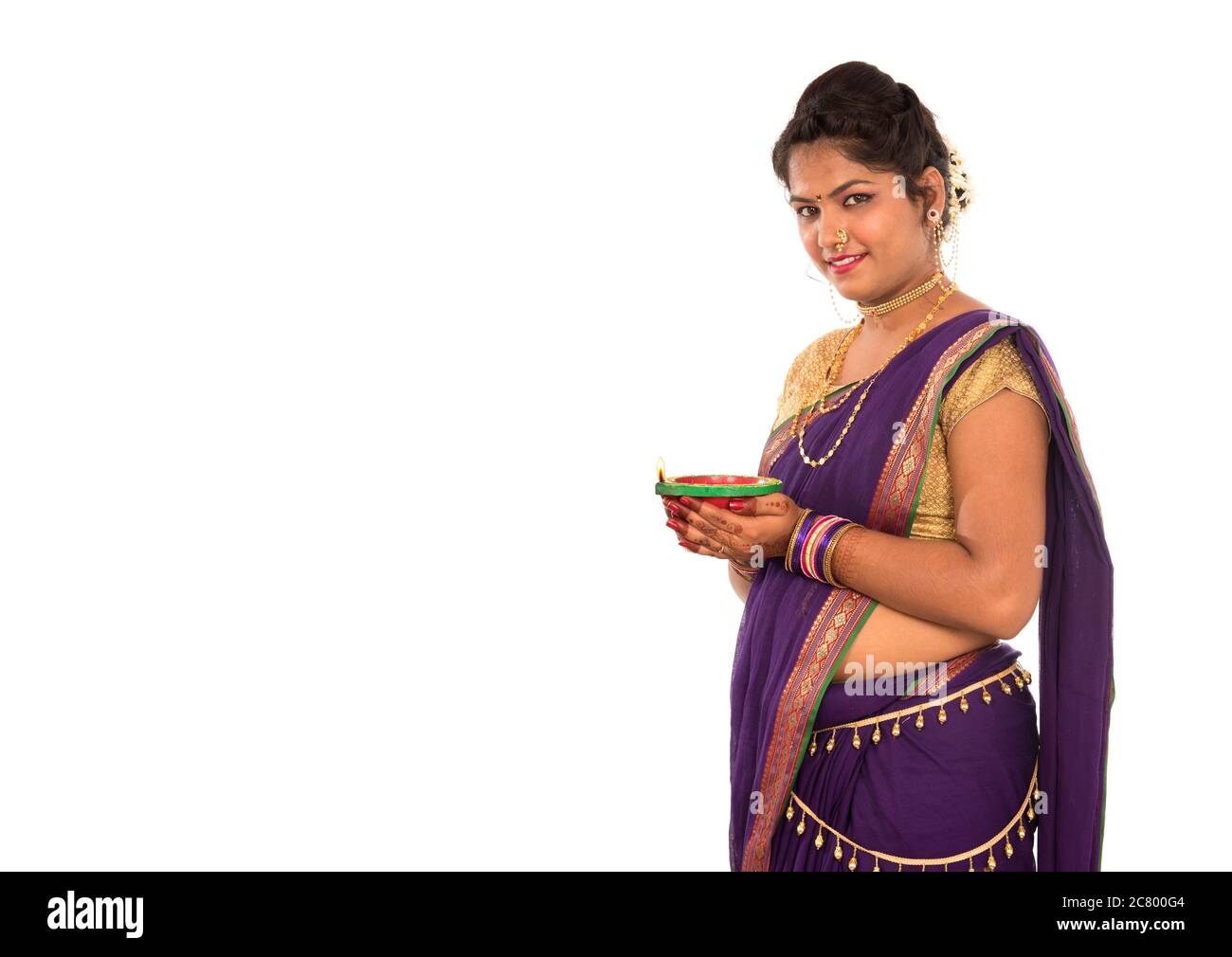 Portrait d'une fille traditionnelle indienne tenant diya, Diwali ou deepavali photo avec les mains des femmes tenant la lampe à huile pendant le festival de lumière sur bac blanc Banque D'Images