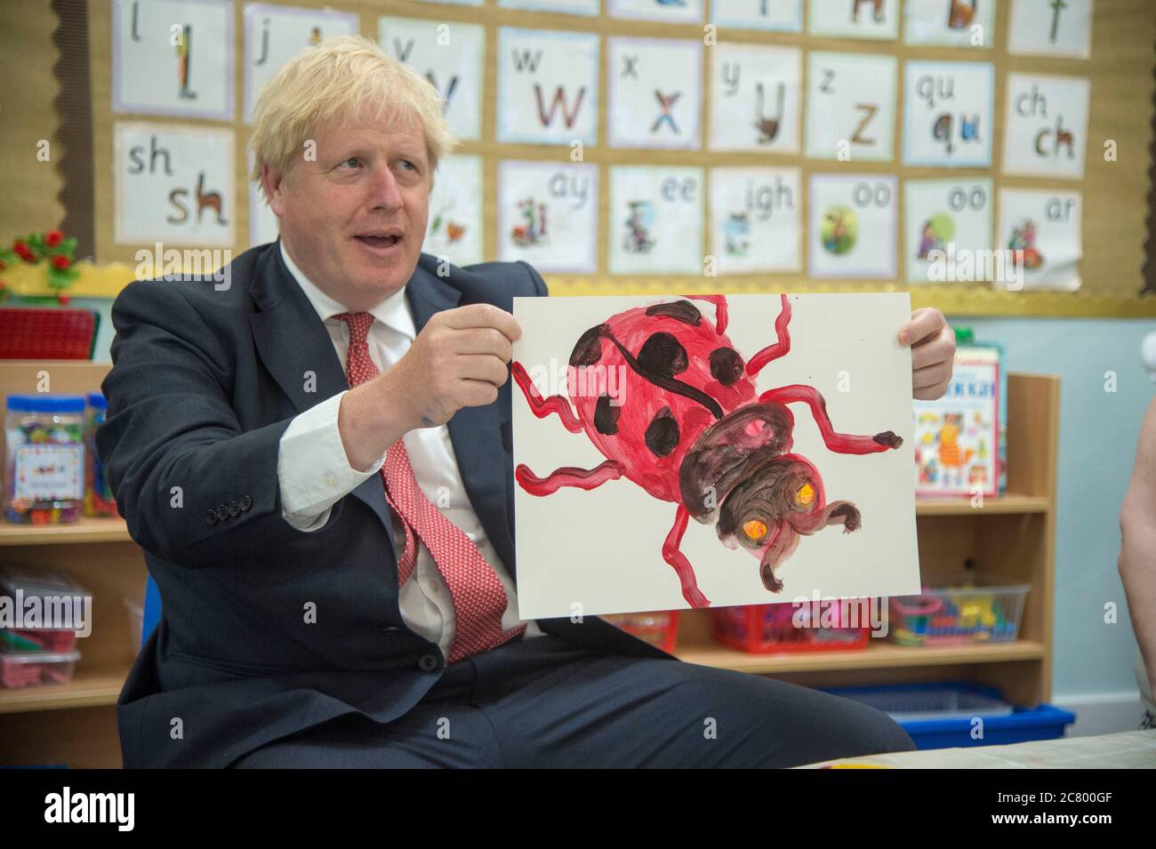 Le Premier ministre Boris Johnson tient sa peinture d'un coccinelle lors d'une visite à l'école de découverte de West Malling, dans le Kent. Banque D'Images