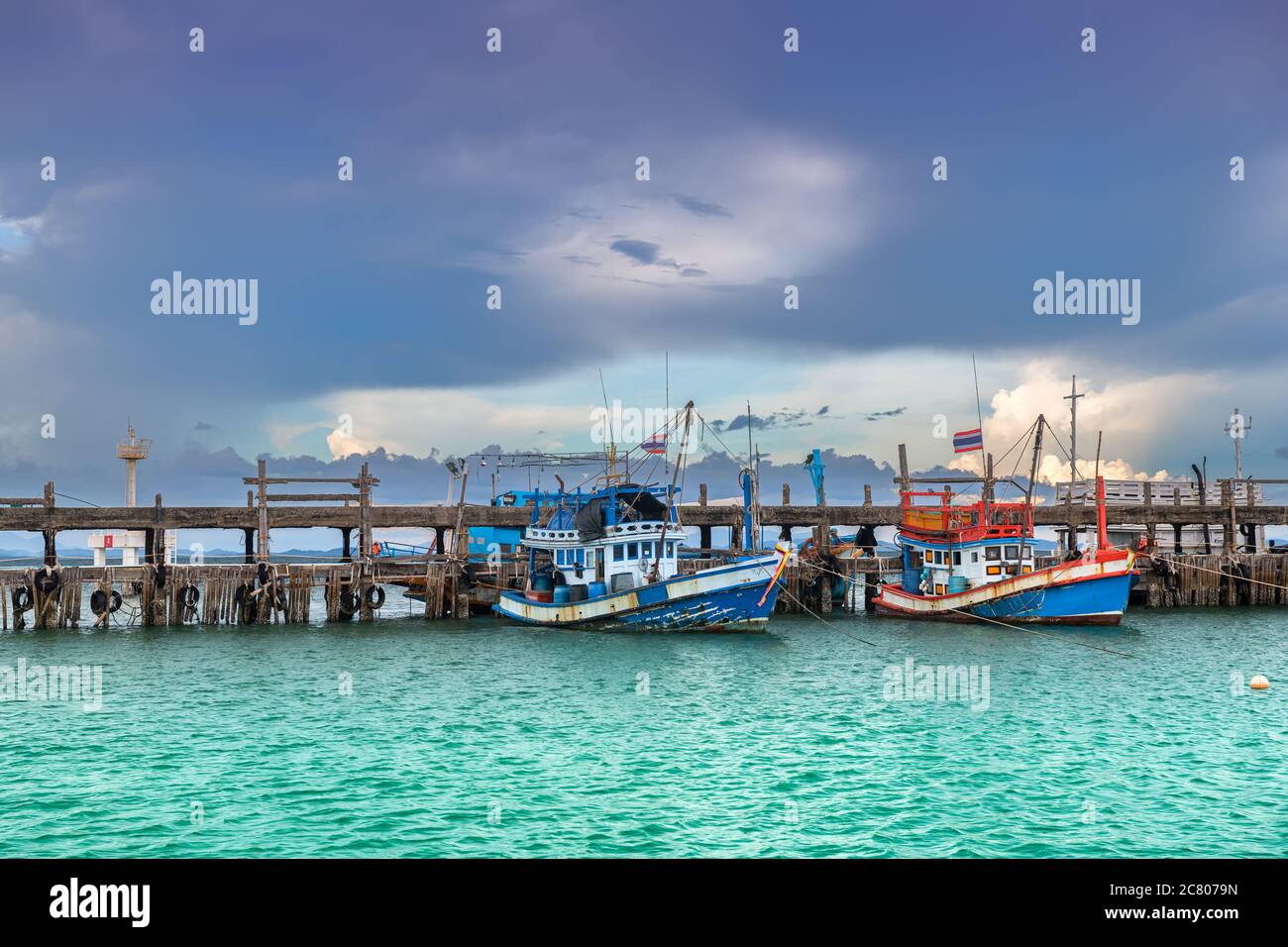 Bateaux de pêche en bois avec éclairage extérieur et ciel nuageux foncé. Banque D'Images