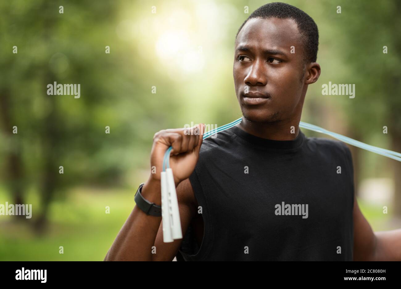 Homme noir sérieux avec entraînement de corde de saut au parc Banque D'Images