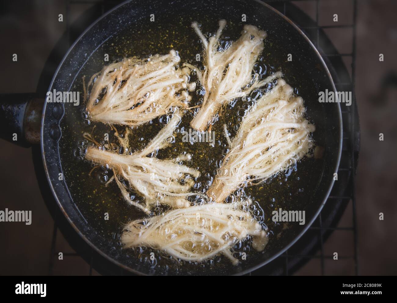 Friture de champignons enoki croustillants à l'huile de cuisson. Banque D'Images