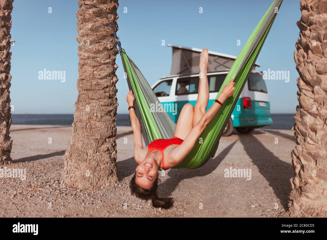 Femme couché dans un hamac entre des palmiers sur la plage Photo Stock -  Alamy