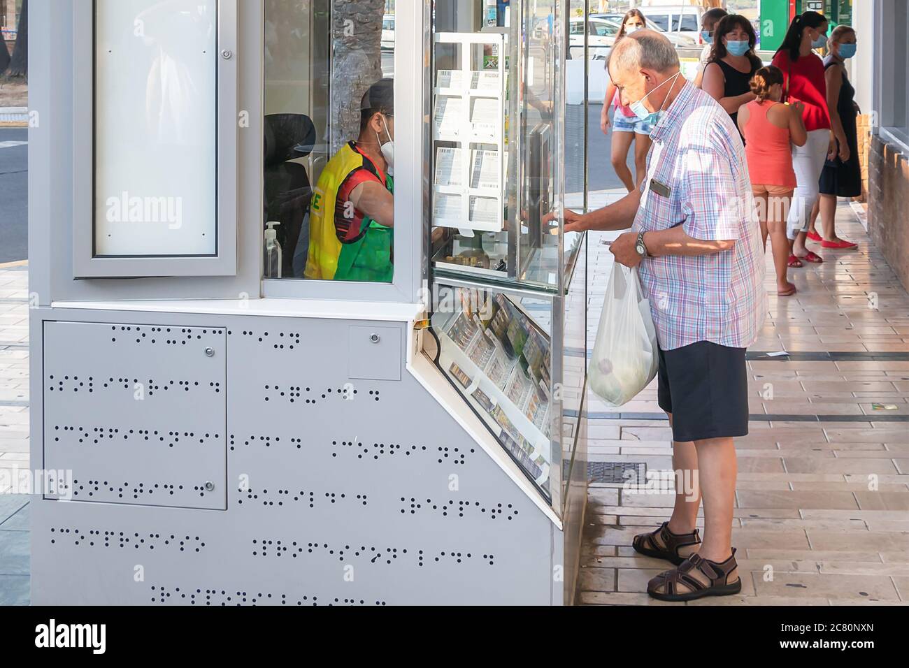 Punta Umbria, Huelva, Espagne - 11 juillet 2020: L'homme dans le masque protecteur achète des billets de loterie à une SEULE BORNE à Punta Umbria, Andalousie, Espagne Banque D'Images