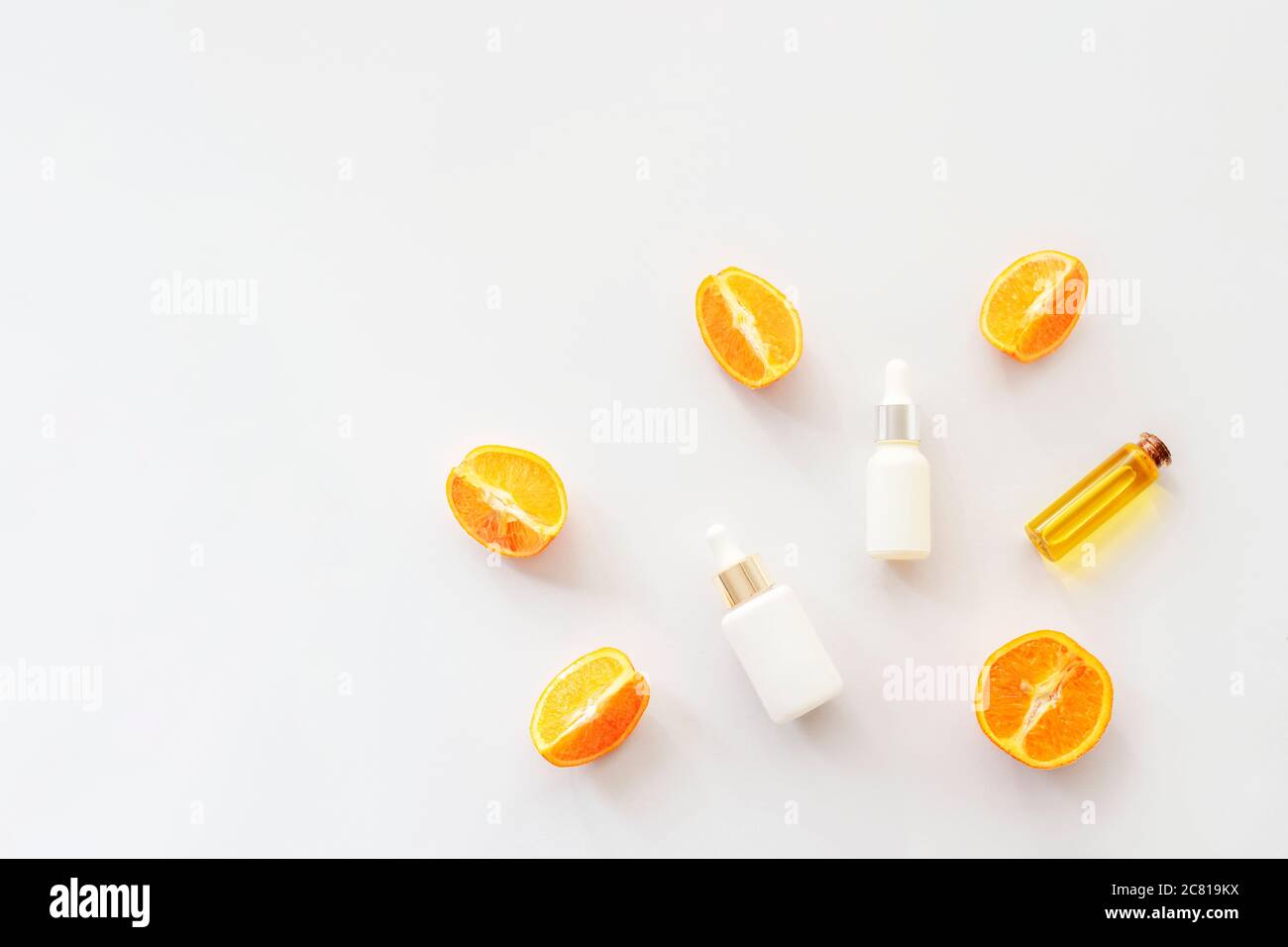 Huile essentielle d'orange et sérums cosmétiques isolés sur fond blanc, vue de dessus, plat. Concept de cosmétiques naturels Banque D'Images