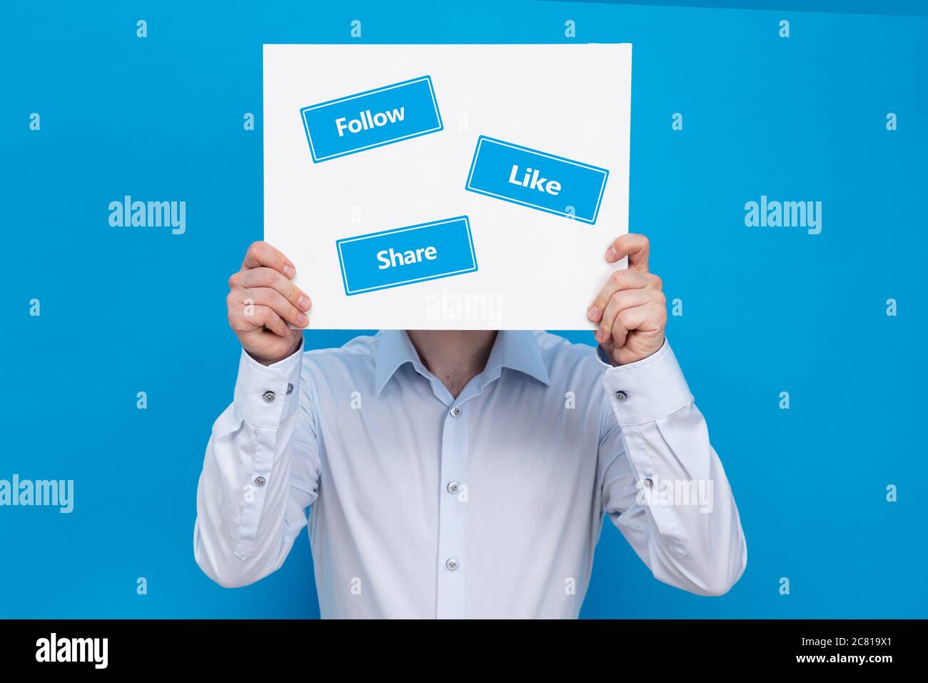 Homme d'affaires couvre son visage avec un tableau blanc avec des panneaux « suivre », « aimer » et « partager ». Conception commerciale du marketing dans les médias sociaux. Banque D'Images