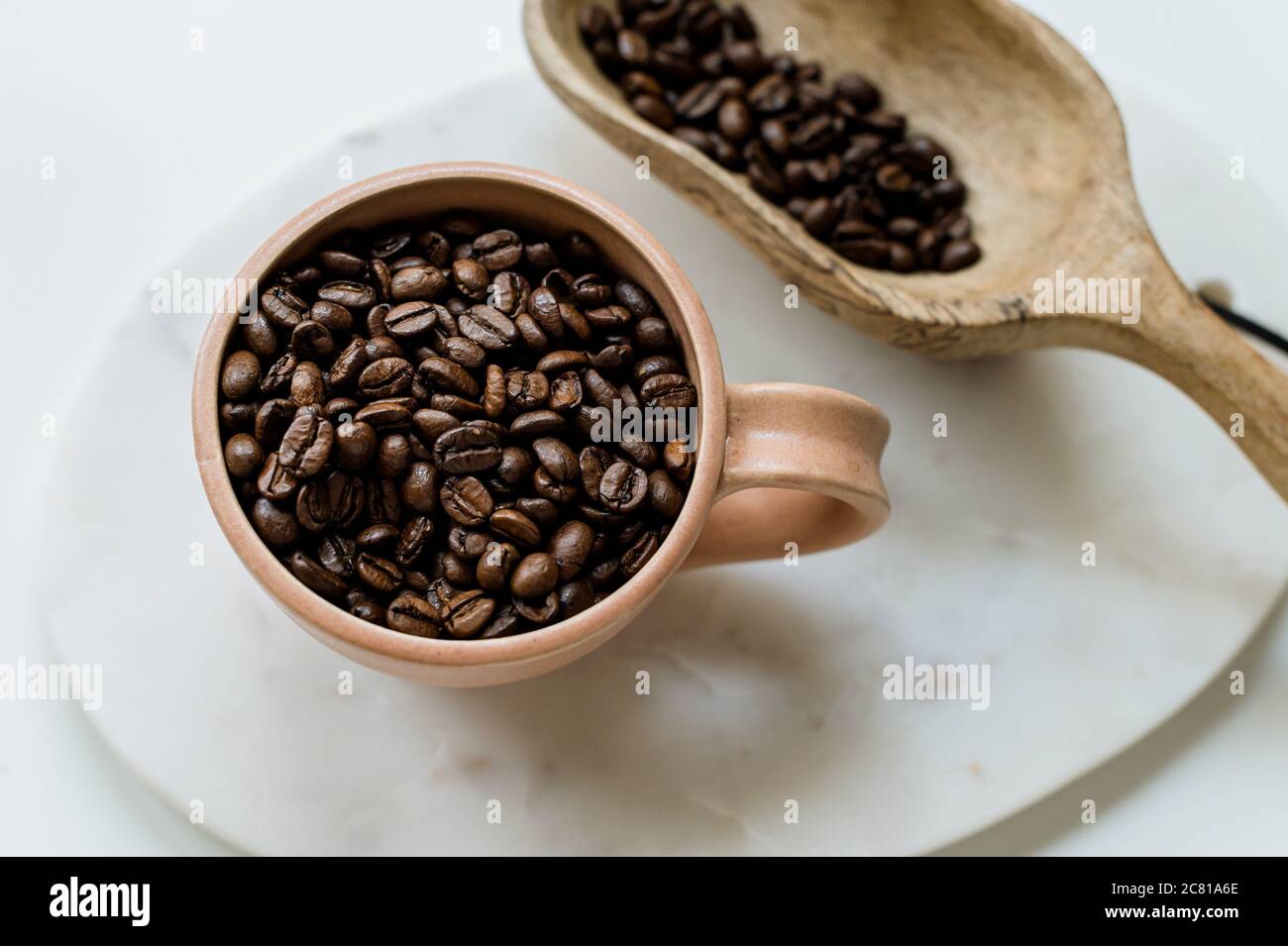 Tasse à café et cuillère en bois avec grains de café entiers Banque D'Images