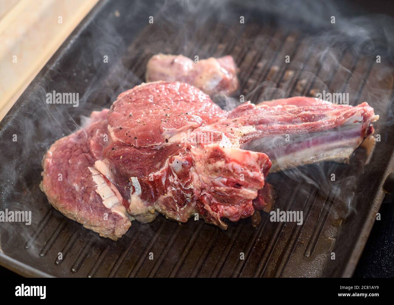 Un grand morceau de viande fraîche de boeuf préparé sur un gril. . Banque D'Images