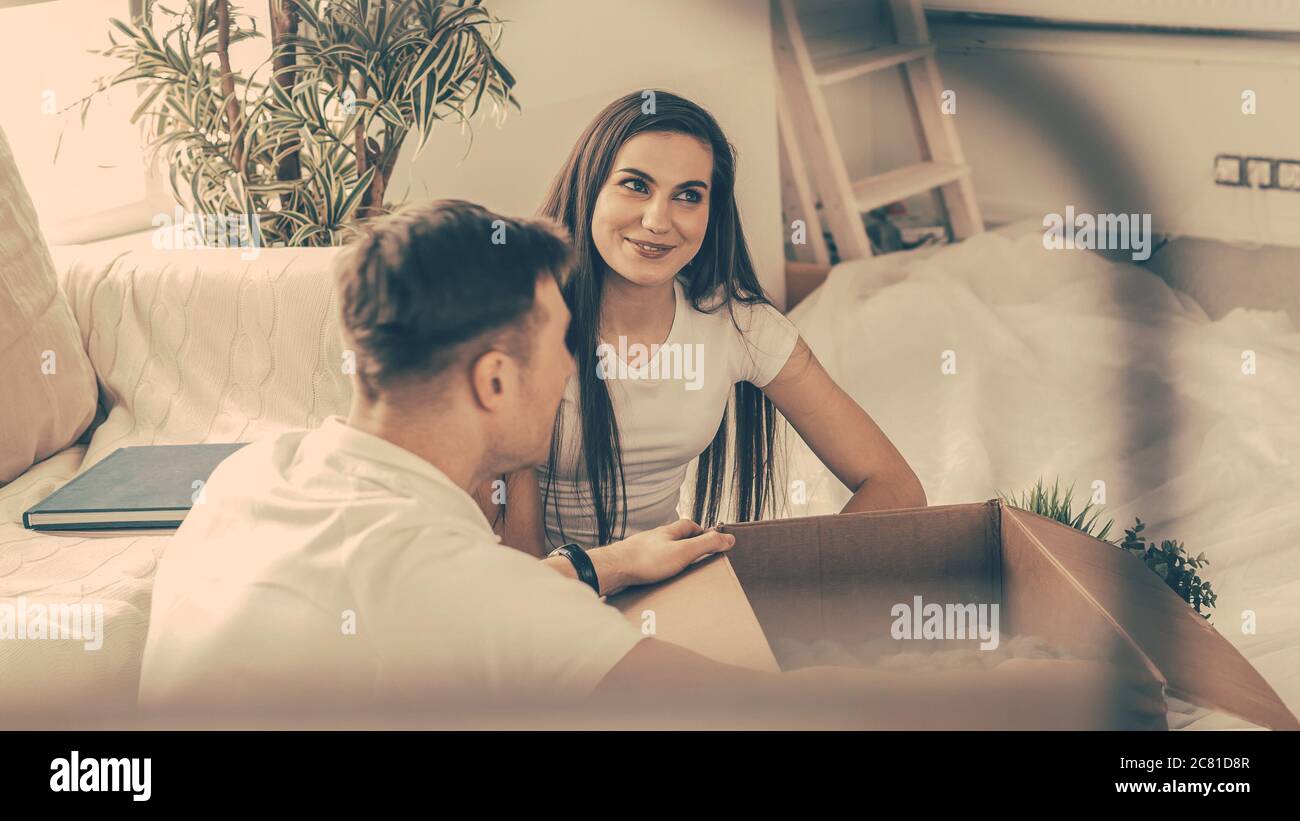 heureux couple ouvrant des boîtes dans un nouvel appartement . Banque D'Images