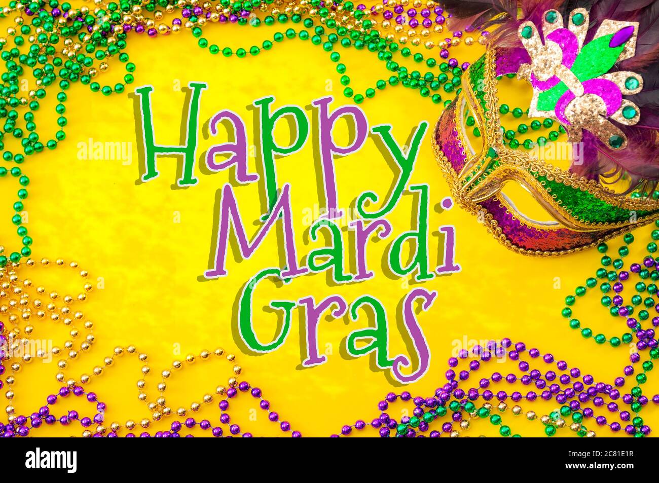 Happy Mardi gras et Mardi Carnival thème avec gros plan sur un masque de visage plein de couleur, plumes et texture et doré, vert et violet Banque D'Images
