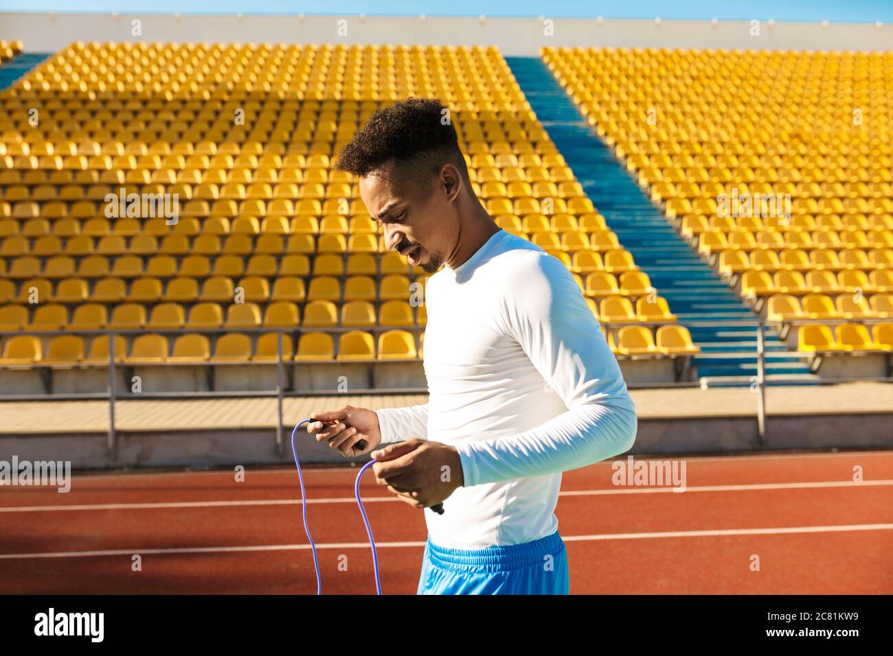 Jeune sportif afro-américain attrayant avec corde à sauter sur l'entraînement au stade Banque D'Images