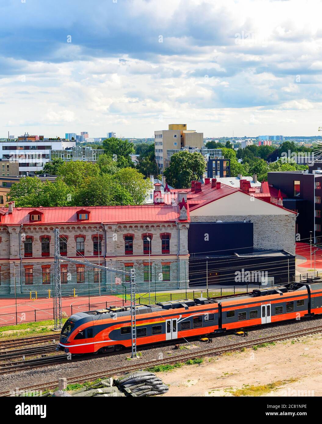 Paysage urbain aérien de la zone industrielle de Tallinn, train à grande vitesse sur le chemin de fer, architecture urbaine moderne sous ciel couvert avec de lourds nuages, Estonie Banque D'Images